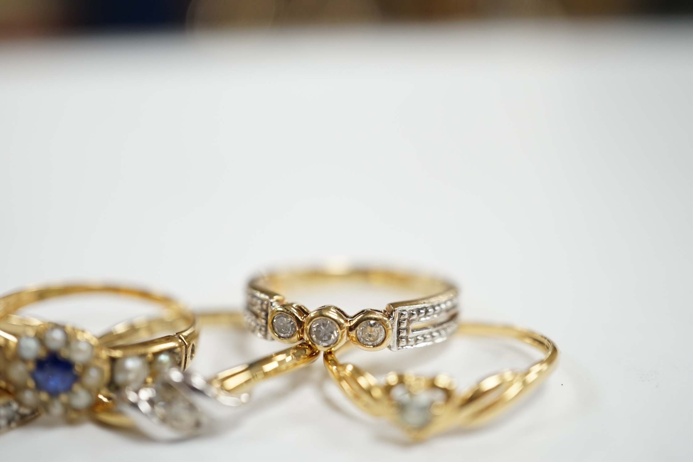 Three assorted modern 9ct gold and diamond set rings, gross 6.5 grams and two other yellow metal and gem set rings.